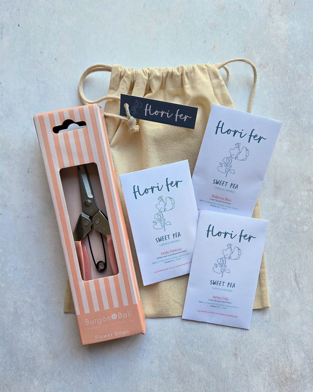 Flori Fer Sweet Pea Seeds with Burgon & Ball Flower Snips in gift packaging with a cotton gift bag on a plain background